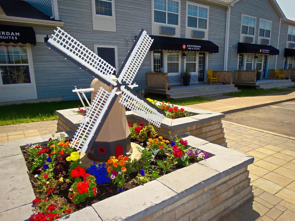 een standbeeld van een windmolen in een bloementuin bij Amsterdam Inn & Suites Moncton in Moncton