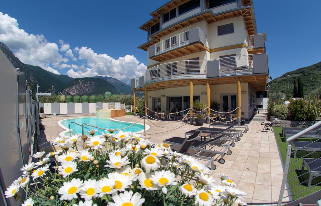 un hôtel avec une piscine et des fleurs sur le balcon dans l'établissement Ecohotel Primavera, à Riva del Garda