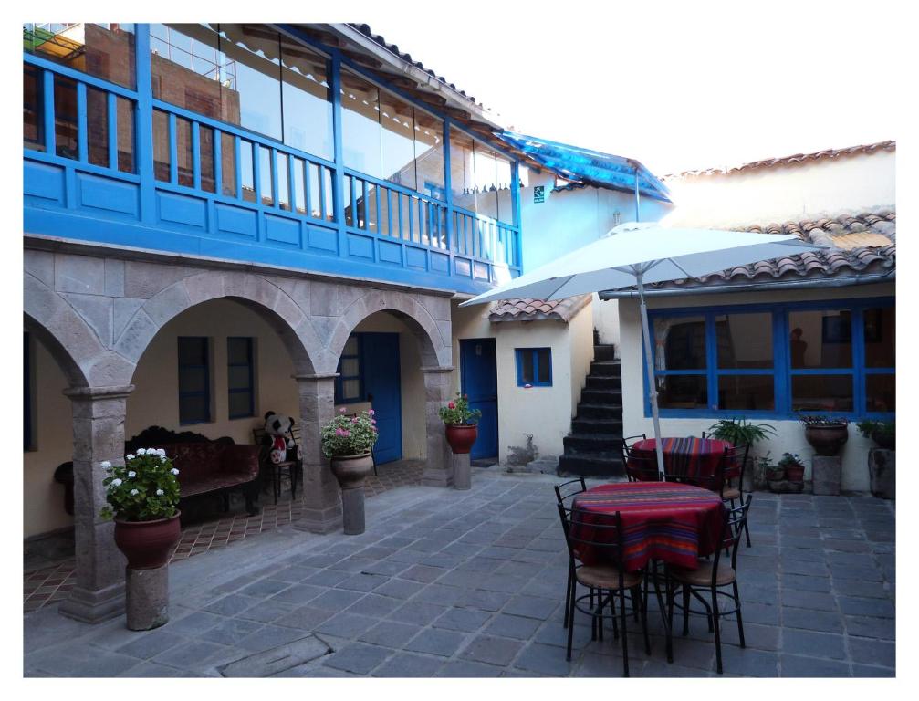 un patio con mesa y sillas frente a un edificio en Chaquill Chak'a, en Cusco