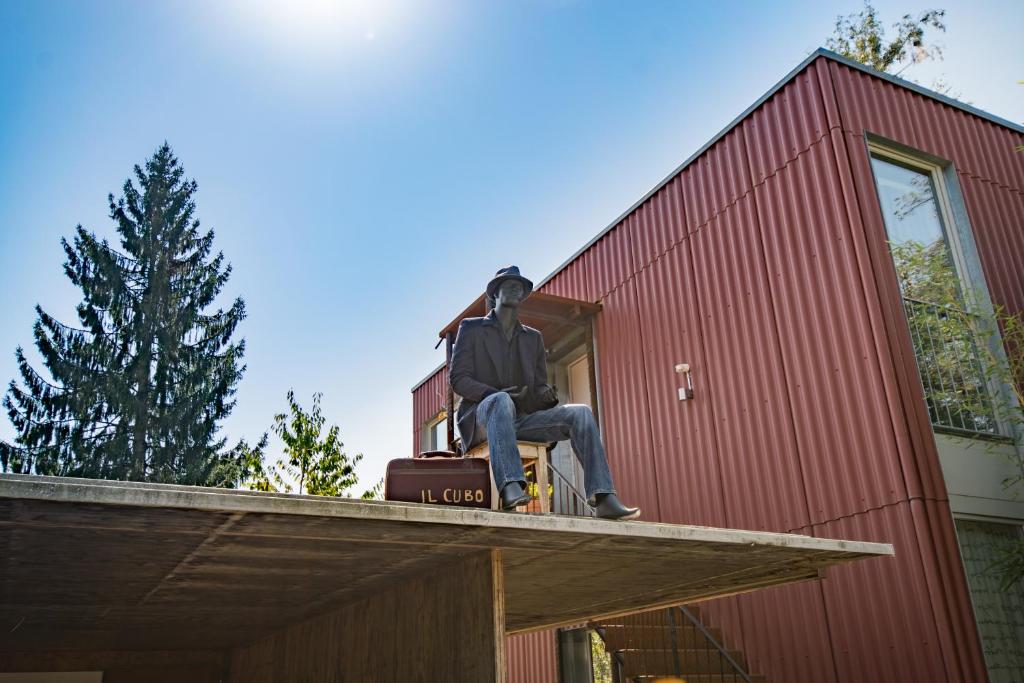 ベルンにあるIl Cuboの赤い建物の屋根に座る男