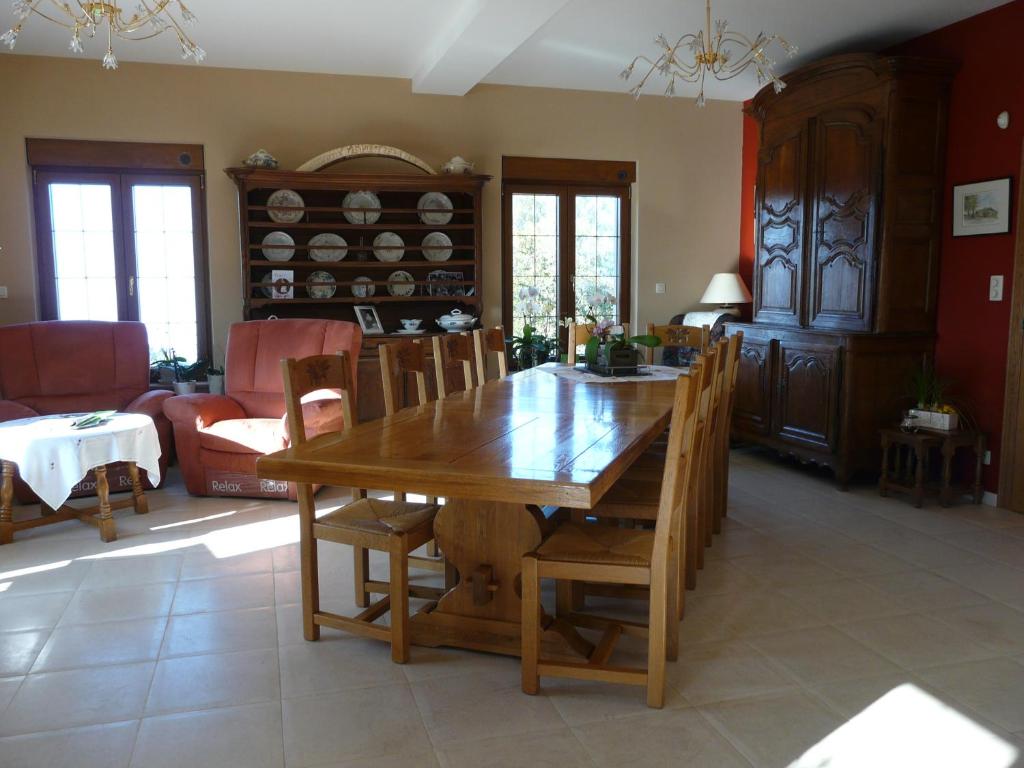 a dining room with a wooden table and chairs at L'orchidée in Rochehaut