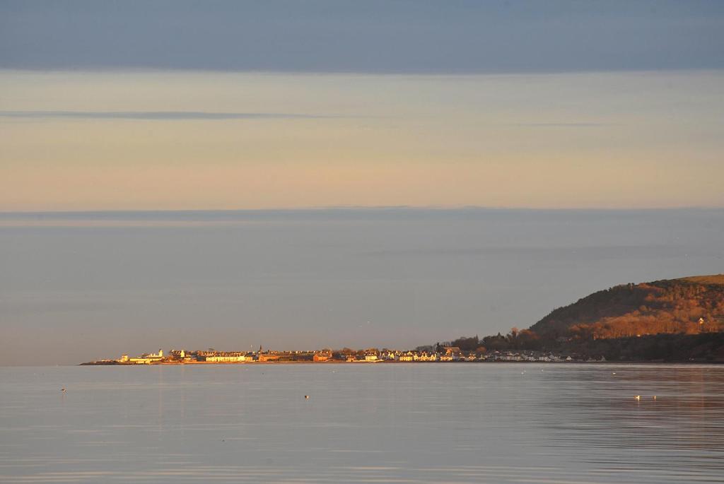 een grote hoeveelheid water met een stad in de verte bij The Royal Hotel Cromarty in Cromarty