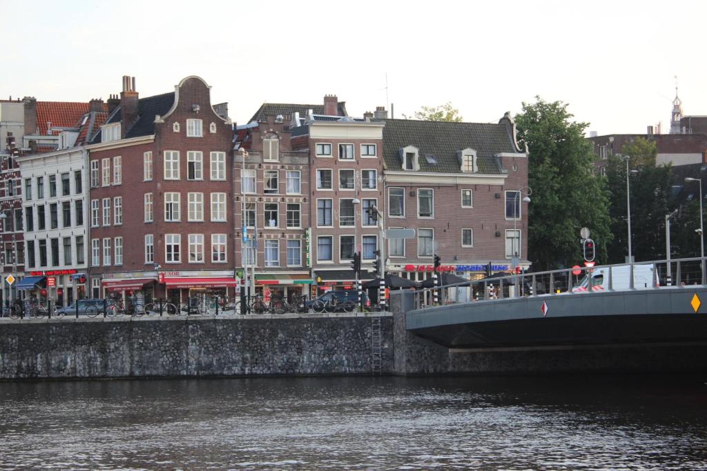 eine Brücke über einen Fluss in einer Stadt mit Gebäuden in der Unterkunft Hotel Restaurant Old Bridge in Amsterdam