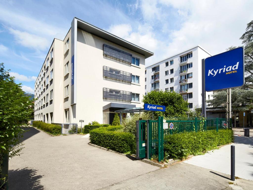 un bâtiment avec un panneau devant lui dans l'établissement Kyriad Grenoble Centre, à Grenoble