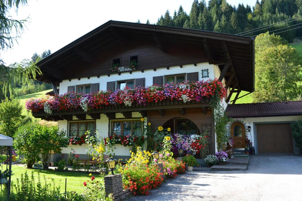 une maison avec des fleurs sur son côté dans l'établissement Haus Thurner, à Wagrain