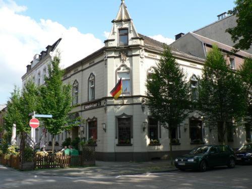 un grande edificio bianco con una bandiera davanti di Stadt-Gut-Hotel Zum Rathaus a Oberhausen