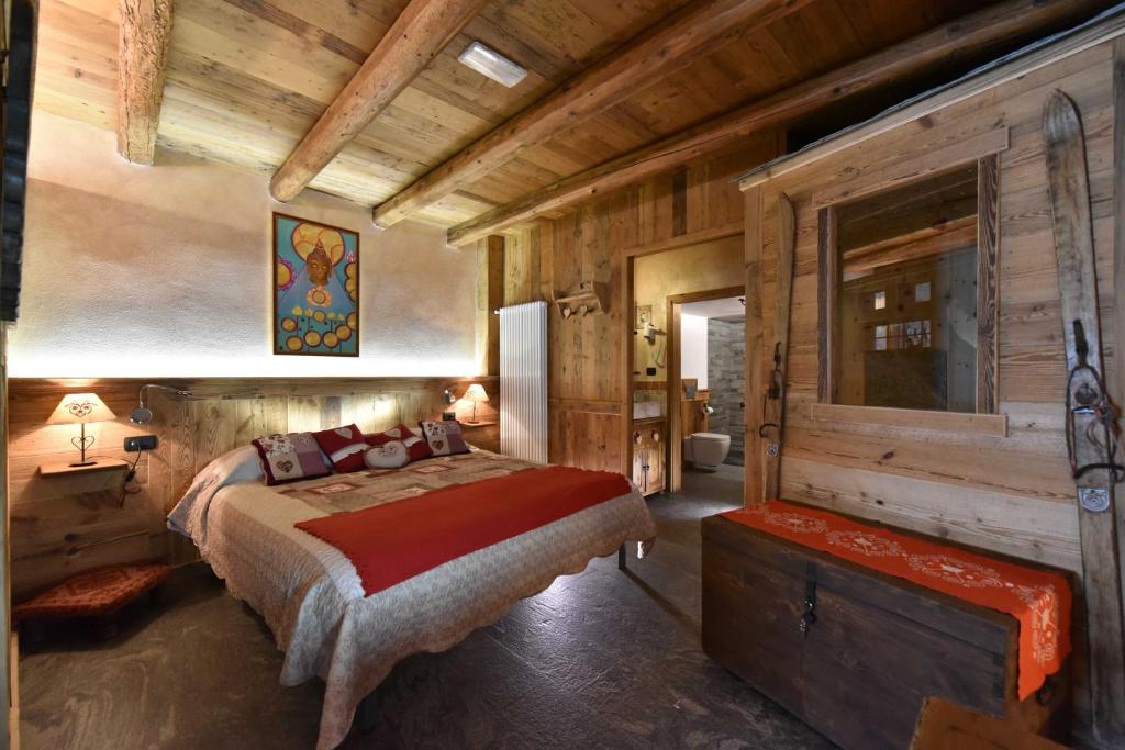 una camera con letto e parete in legno di L'Ancien Paquier Chambre D'Hotes a Valtournenche