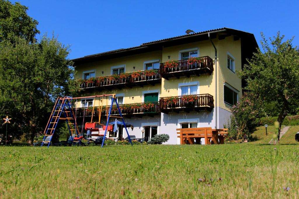 - un bâtiment avec une aire de jeux en face dans l'établissement Pension Sonnengrund, à Reifnitz