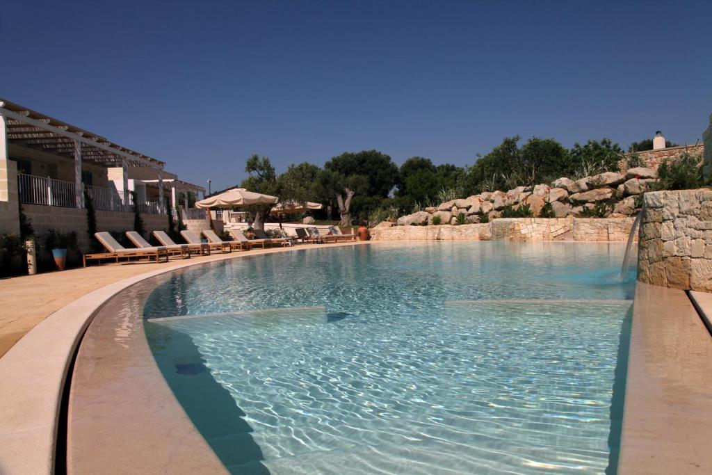 ein großer Pool mit Stühlen in einem Resort in der Unterkunft Borgo de li Santi in Otranto