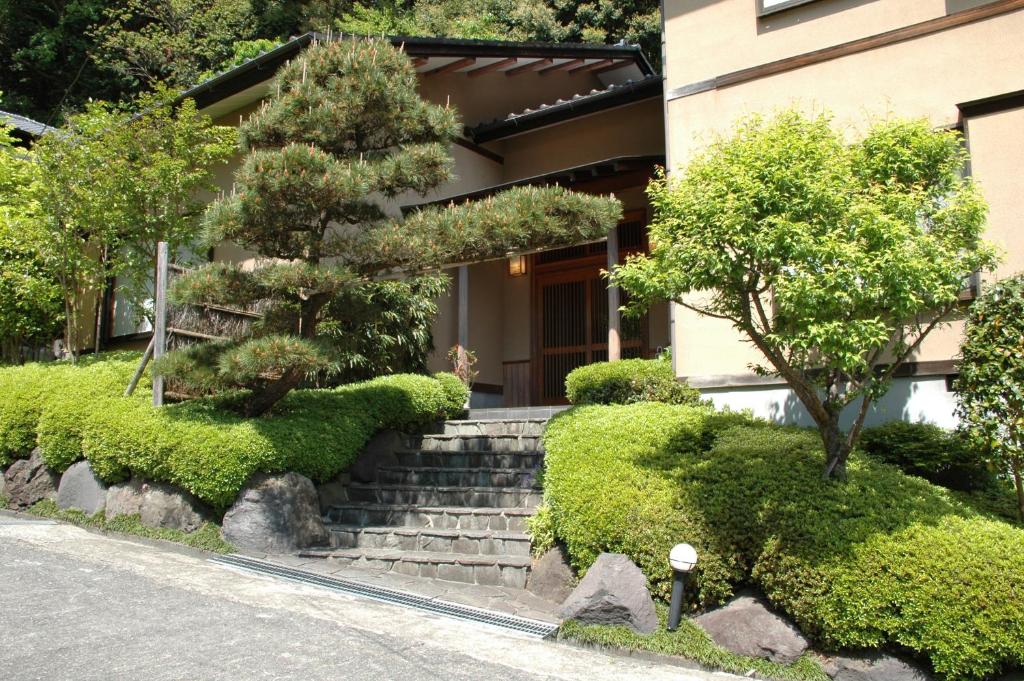 une maison avec des escaliers en face d'un bâtiment dans l'établissement Hoshi Meguri, à Shimoda