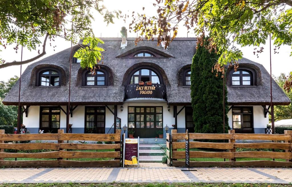 um edifício com uma cerca em frente em Gasthof Laci Betyár em Hajdúszoboszló