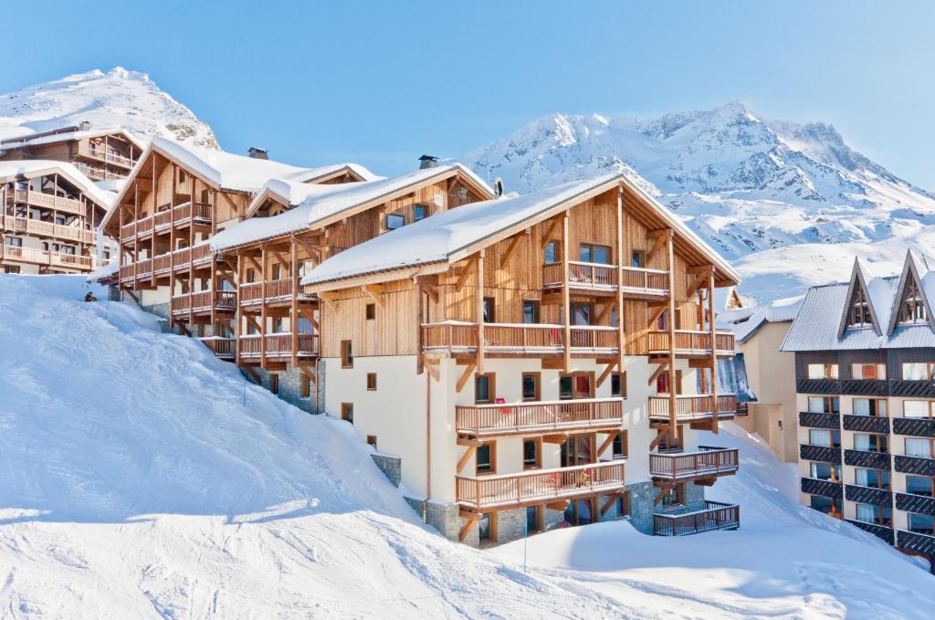 ein Resort im Schnee mit Bergen im Hintergrund in der Unterkunft Residence Montana Plein Sud in Val Thorens