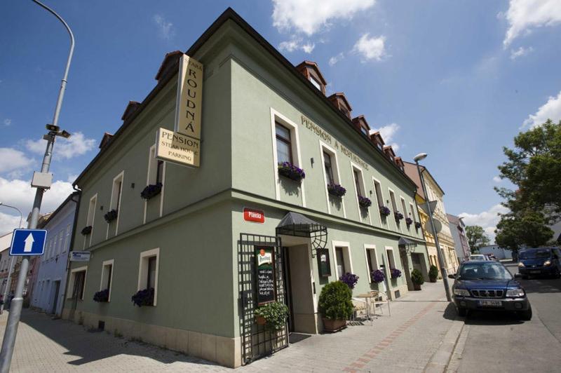 un bâtiment vert sur le côté d'une rue dans l'établissement Penzion a Restaurace Stará Roudná, à Plzeň