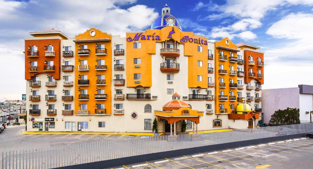 een groot geel en wit gebouw met een bord erop bij Hotel María Bonita Consulado Americano in Ciudad Juárez