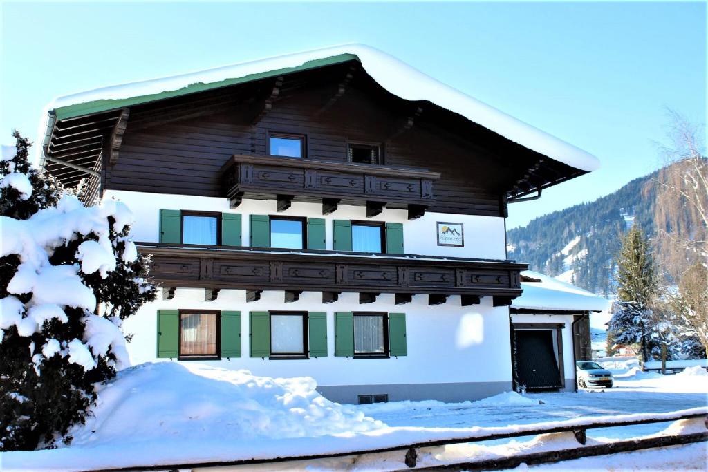 ein Gebäude mit Schnee auf dem Boden davor in der Unterkunft Alpenzeit in Flachau