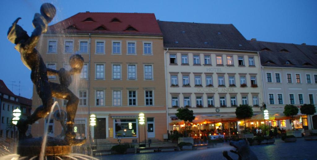 une fontaine en face d'un bâtiment d'une ville dans l'établissement Hotel Goldener Anker, à Torgau