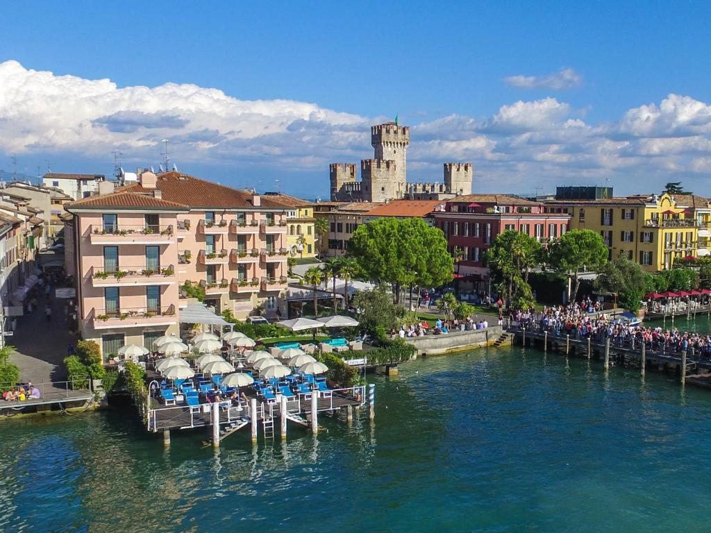 widok na rzekę z krzesłami i budynkami w obiekcie Hotel Eden w Sirmione