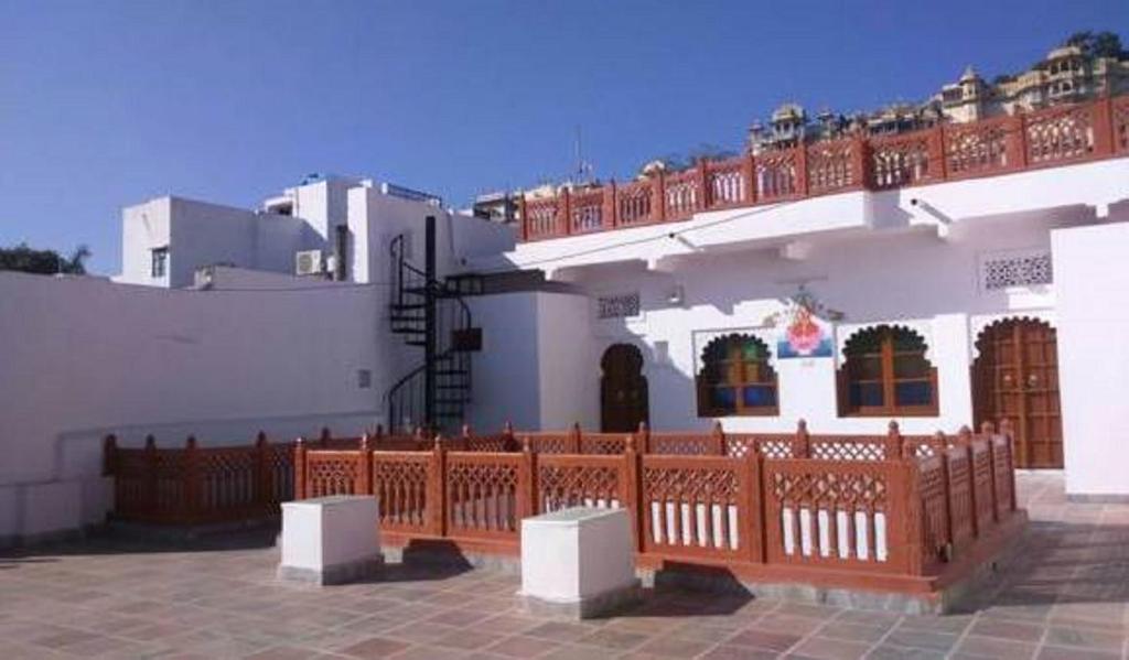 um edifício com uma cerca de madeira em frente em Hari Niwas Guest House em Udaipur