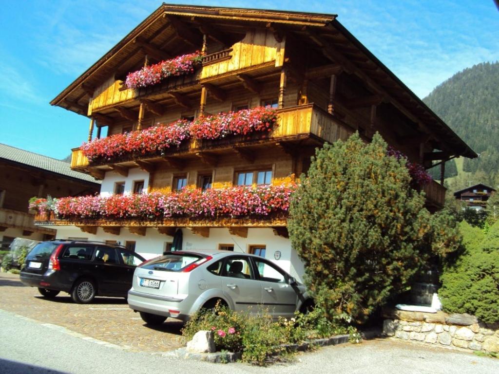 un edificio con flores a un lado. en Haus Postfeld, en Alpbach