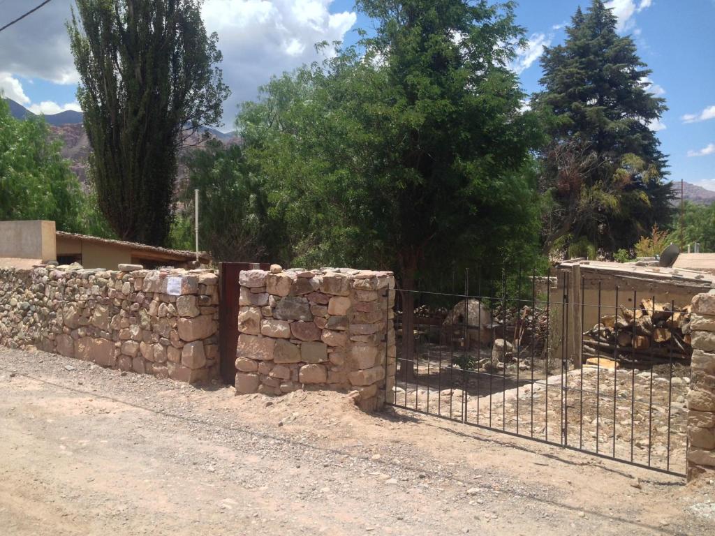 una valla frente a una pared de piedra en La Pirquita, en Tilcara