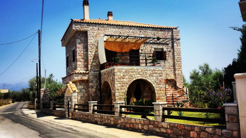 - un bâtiment en pierre avec un balcon dans une rue dans l'établissement Niko's Stone Guest House, à Plitra