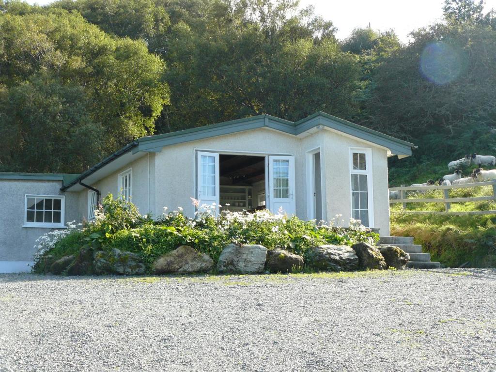 une petite maison avec des fleurs devant elle dans l'établissement Roberts’ Cottage, à Westport