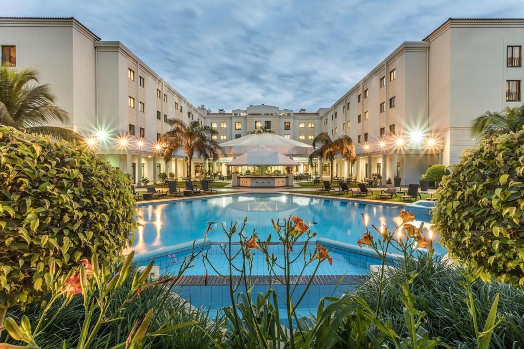 un hotel con una gran piscina frente a un edificio en Hotel Vip Grand Maputo en Maputo