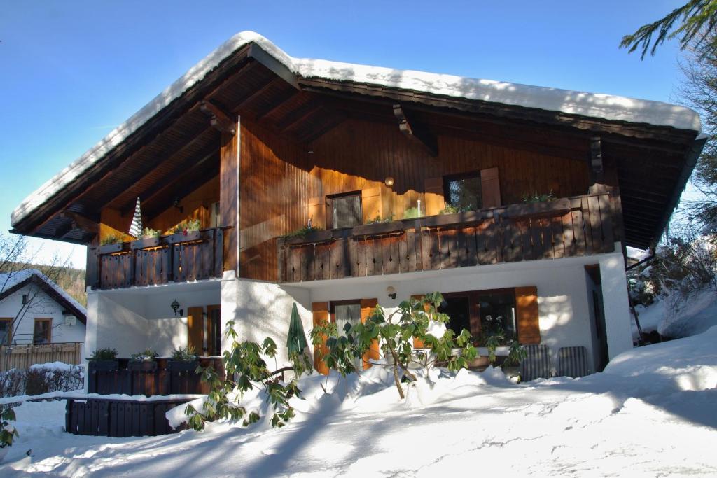 una casa nella neve con balcone di Apartments Haus Martin a Bayerisch Eisenstein