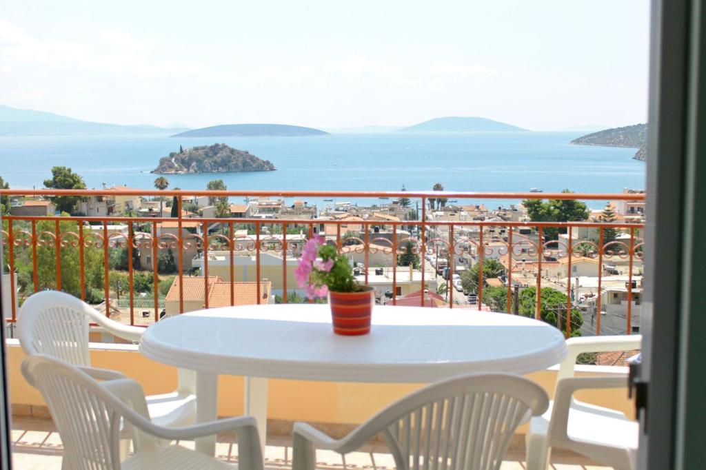 una mesa y sillas en un balcón con vistas al océano en Iliana Apartments, en Tolo