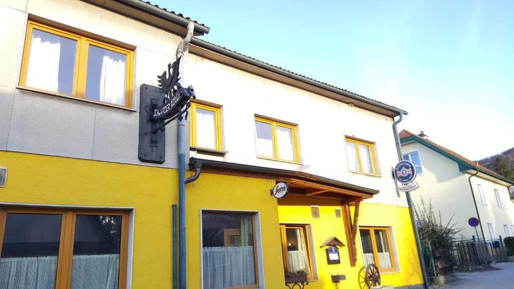 um edifício amarelo e branco numa rua em Gasthaus Schwarzer Adler em Altenberg