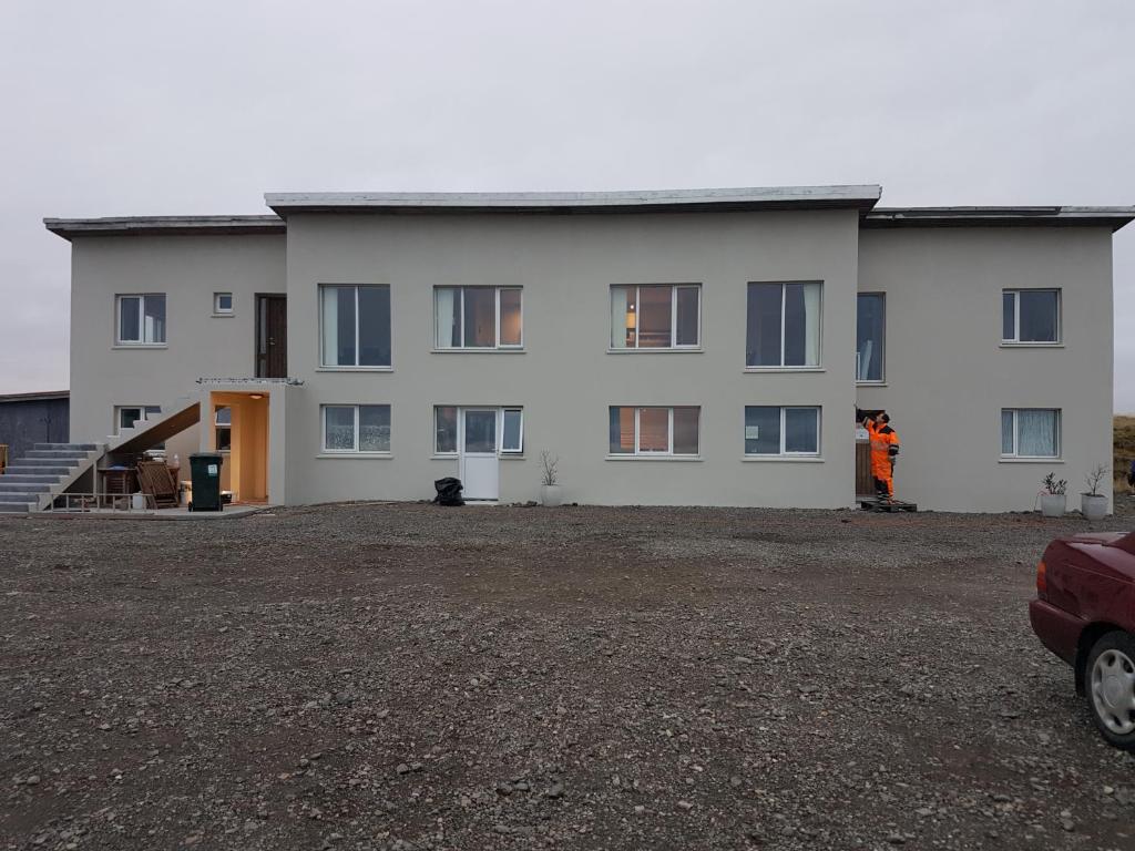 ein großes weißes Gebäude mit vielen Fenstern in der Unterkunft Hafnarnes in Höfn