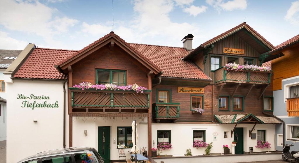 un edificio con flores en sus balcones en Das kleine Bio Hotel Tiefenbach, en Schladming