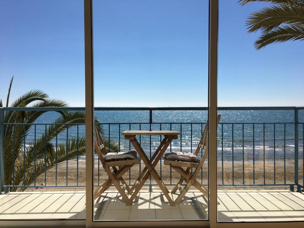 a table and two chairs on a balcony with the beach at InSitges Sant Sebastia's Beach in Sitges