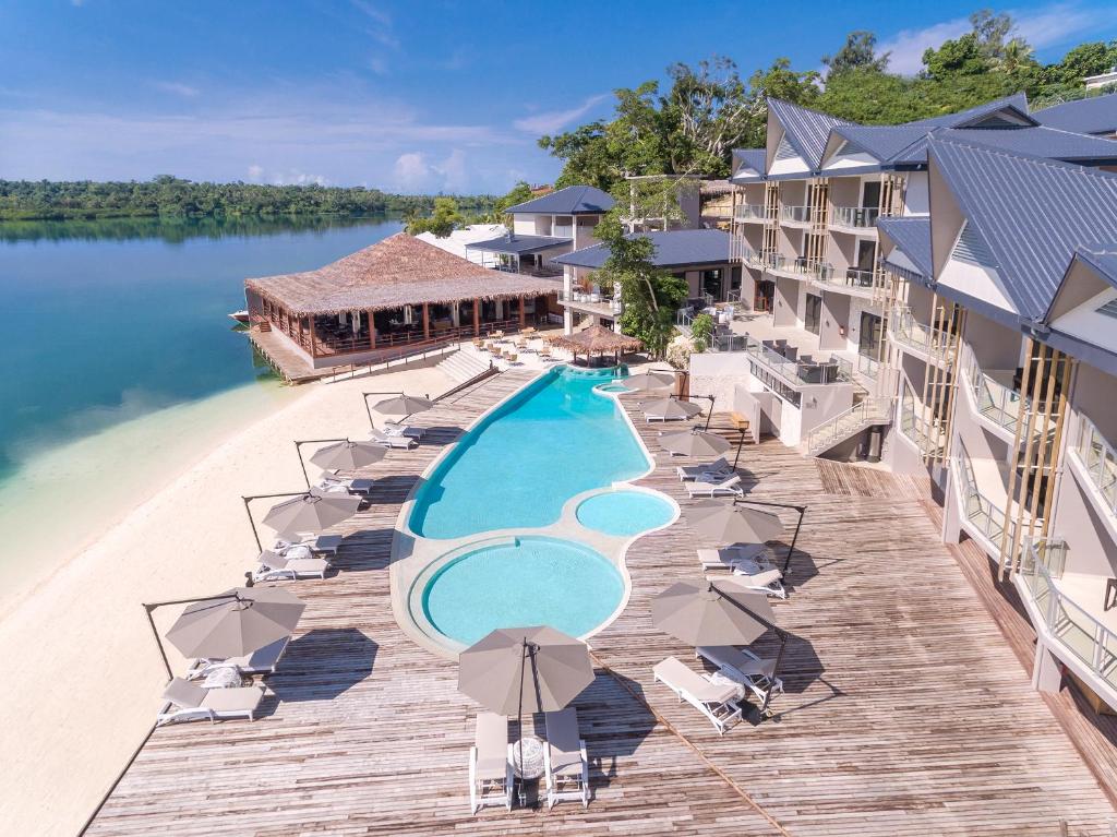 uma vista aérea de um resort com uma piscina e cadeiras em Ramada Resort by Wyndham Port Vila em Port Vila