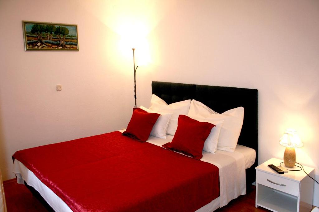 una camera con letto rosso e bianco con cuscini rossi di Rooms and Apartments Emily a Spalato (Split)