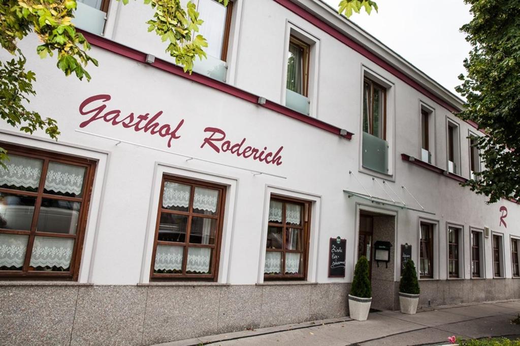 een wit gebouw met de naam van een restaurant bij Gasthof Roderich Hotel in Langenzersdorf