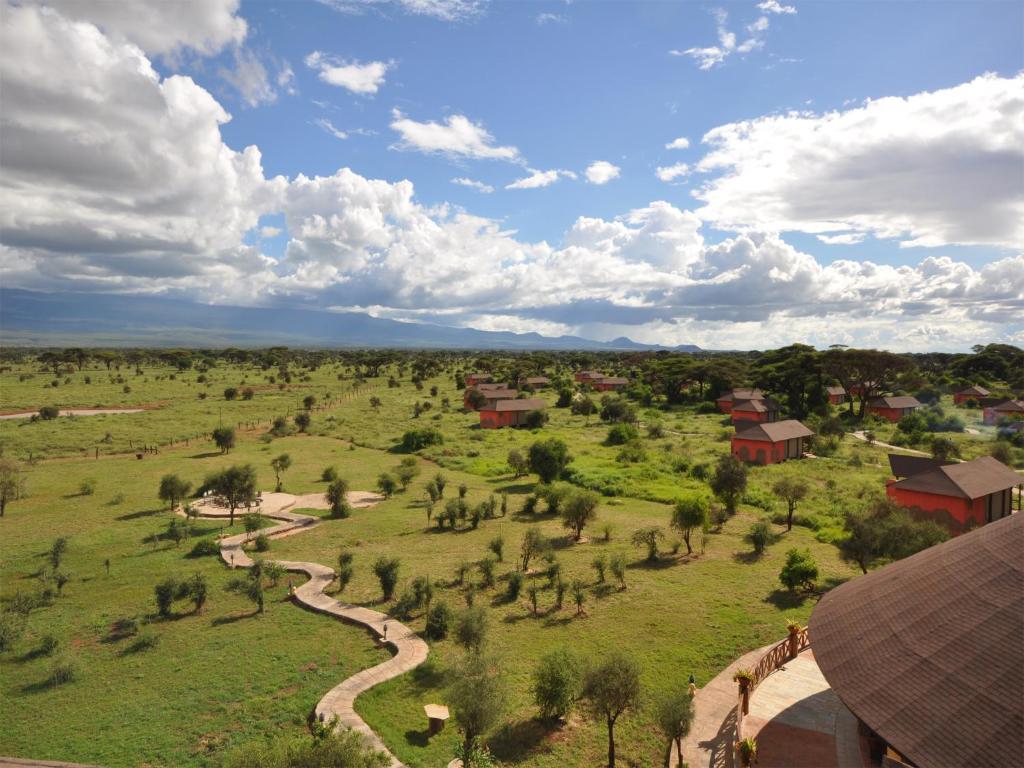 une vue aérienne sur un champ planté d'arbres et de bâtiments dans l'établissement Kilima Safari Camp, à Amboseli