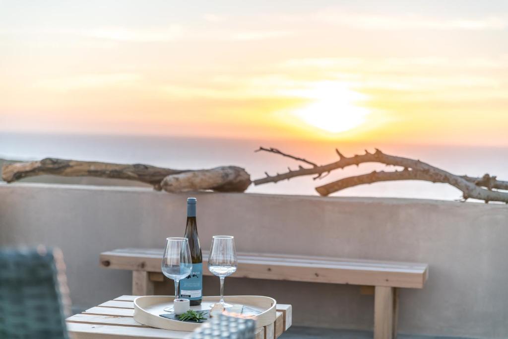 - une table avec une bouteille de vin et deux verres dans l'établissement Eco Soul Ericeira Guesthouse - Adults Only, à Ericeira