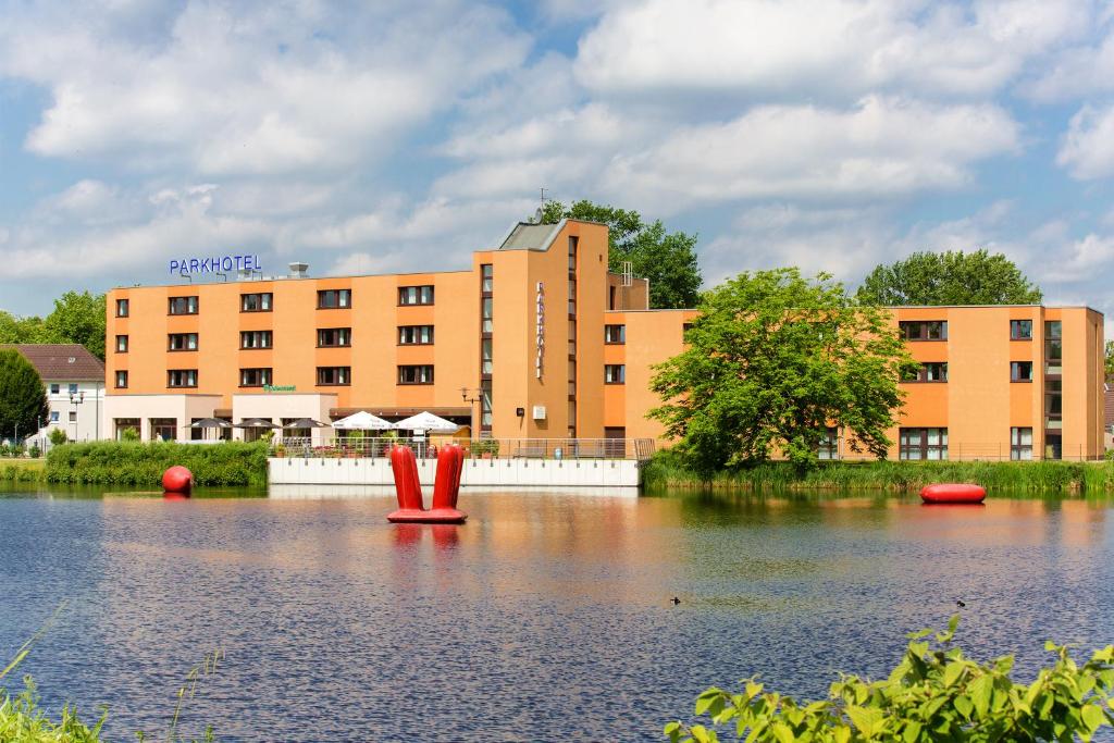 een groot gebouw voor een waterlichaam bij Montana Parkhotel Marl in Marl