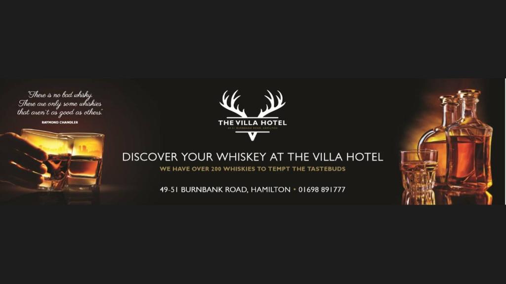 eine Flasche Whiskey, ein Glas und eine Flasche Alkohol in der Unterkunft Villa Hotel in Hamilton