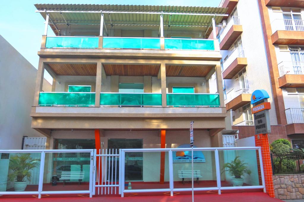 een appartementencomplex met een balkon met stoelen erop bij Pousada Águas do Forte in Cabo Frio