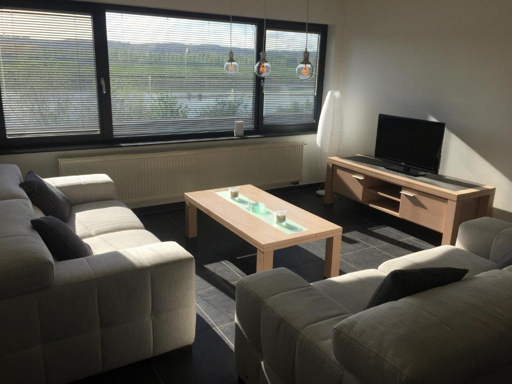 a living room with two couches and a coffee table at Maaszicht in Maasmechelen