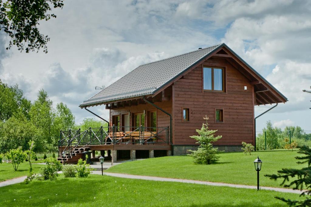 une grande maison en bois avec un toit en gambrel dans l'établissement Vila Viesai, à Trakai