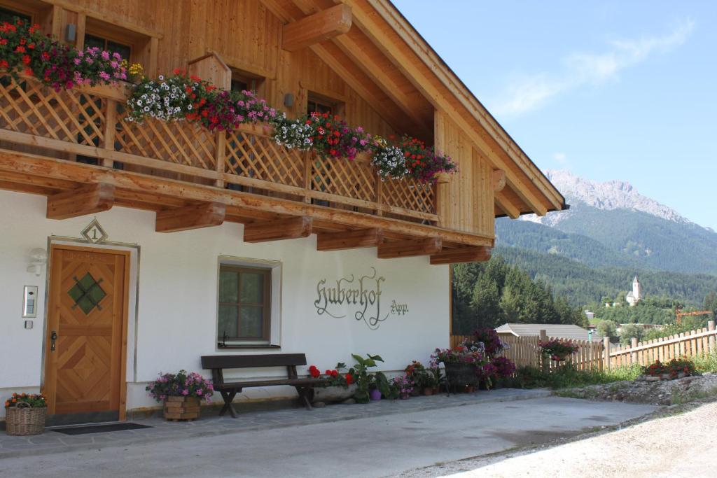 een gebouw met een balkon met bloemen erop bij Huberhof in San Candido