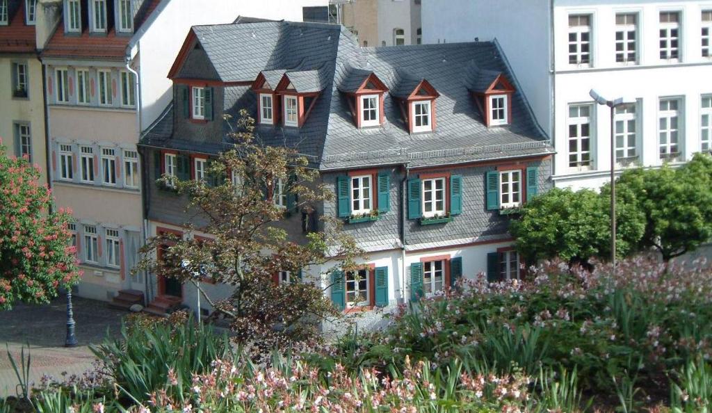 a large house with green shuttered windows in a city at Appartement Kirschgarten Mainz Rochusstraße in Mainz