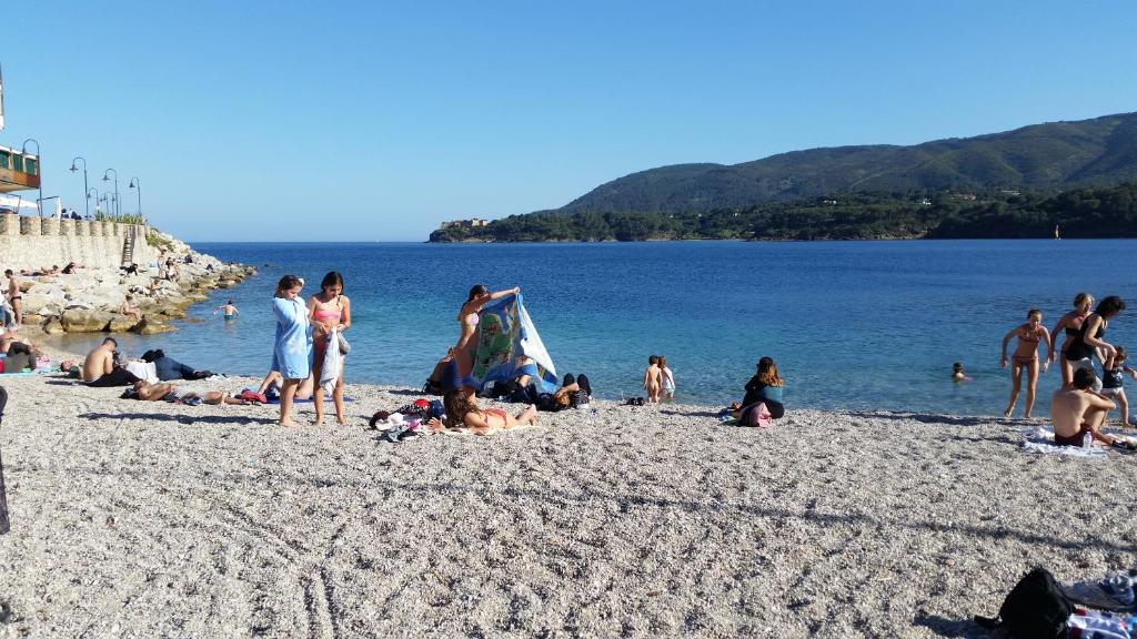 un grupo de personas en una playa cerca del agua en Casa Porto Azzurro, en Porto Azzurro