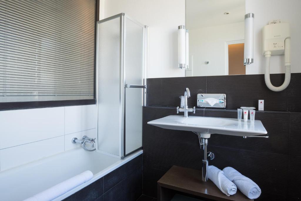 bagno con lavandino, doccia e specchio di Villa 81 a Deauville