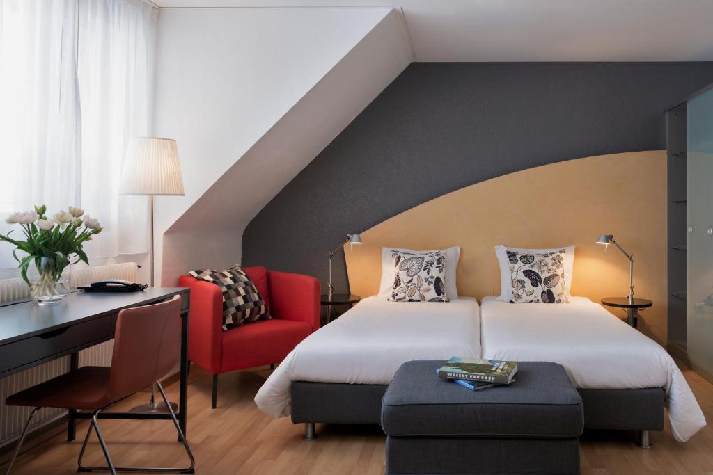 - une chambre avec un lit, un bureau et une chaise dans l'établissement Hotel La Pergola, à Berne