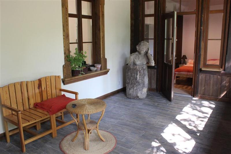 a room with a bench and a table and a statue at Willa Widok - Apartament Naleczow in Nałęczów