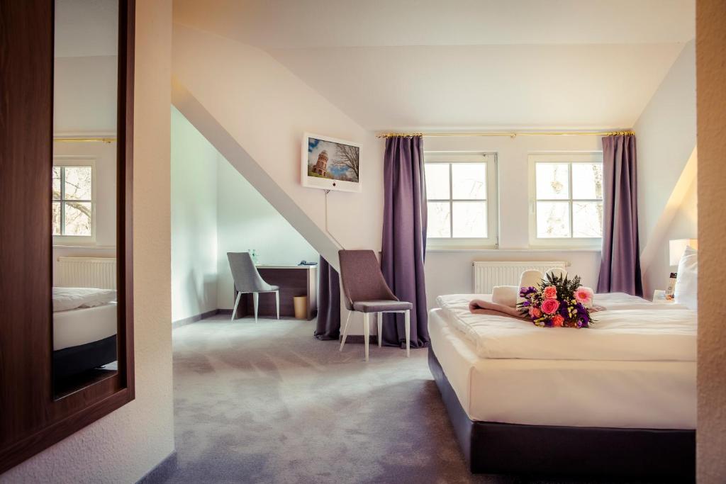 une chambre d'hôtel avec un lit fleuri dans l'établissement Hotel am Rugard, à Bergen auf Rügen